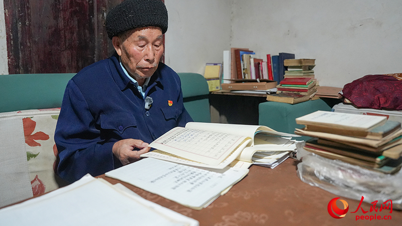 陈天才在翻阅自己收集整理的红军故事。人民网记者 李发兴摄